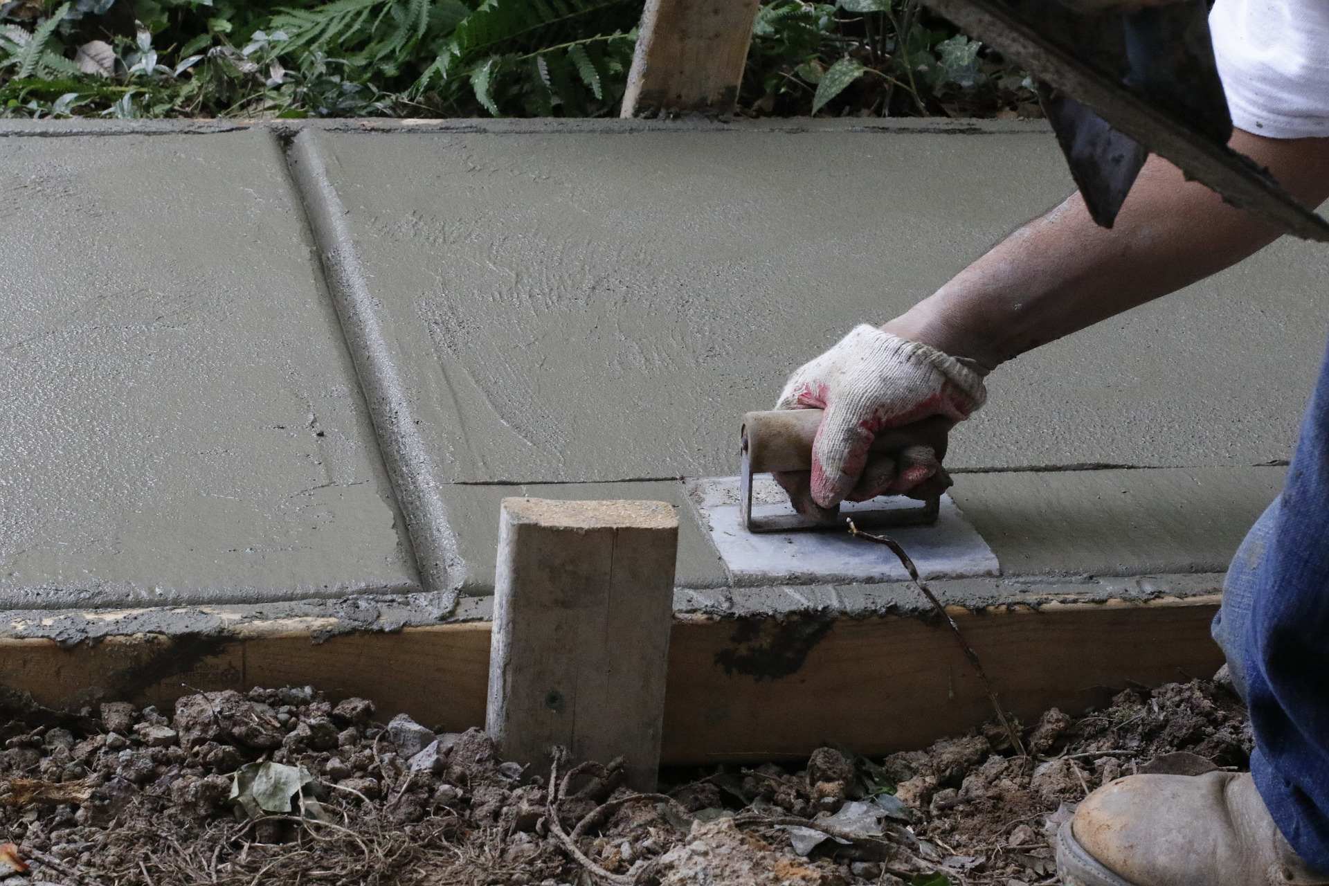 A person using a sander to smooth the concrete.